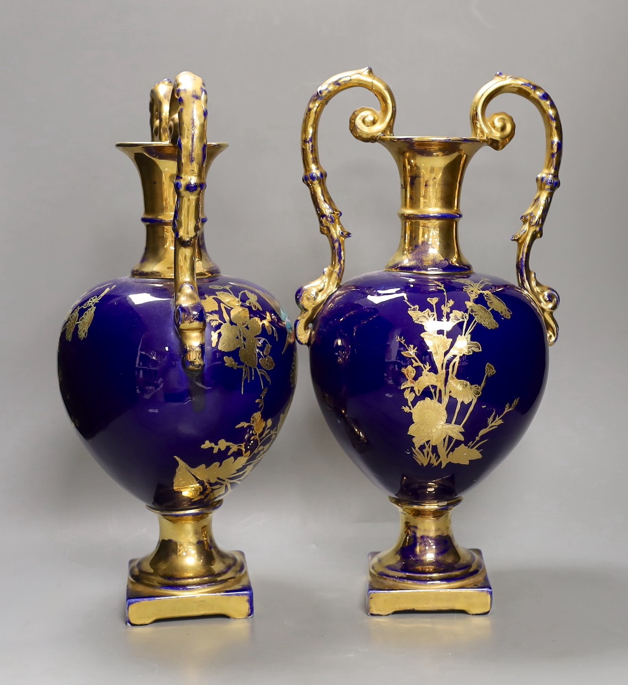 A pair of blue painted two-handled gilt pottery vases with birds amongst ornate gilt decoration. 41cm high